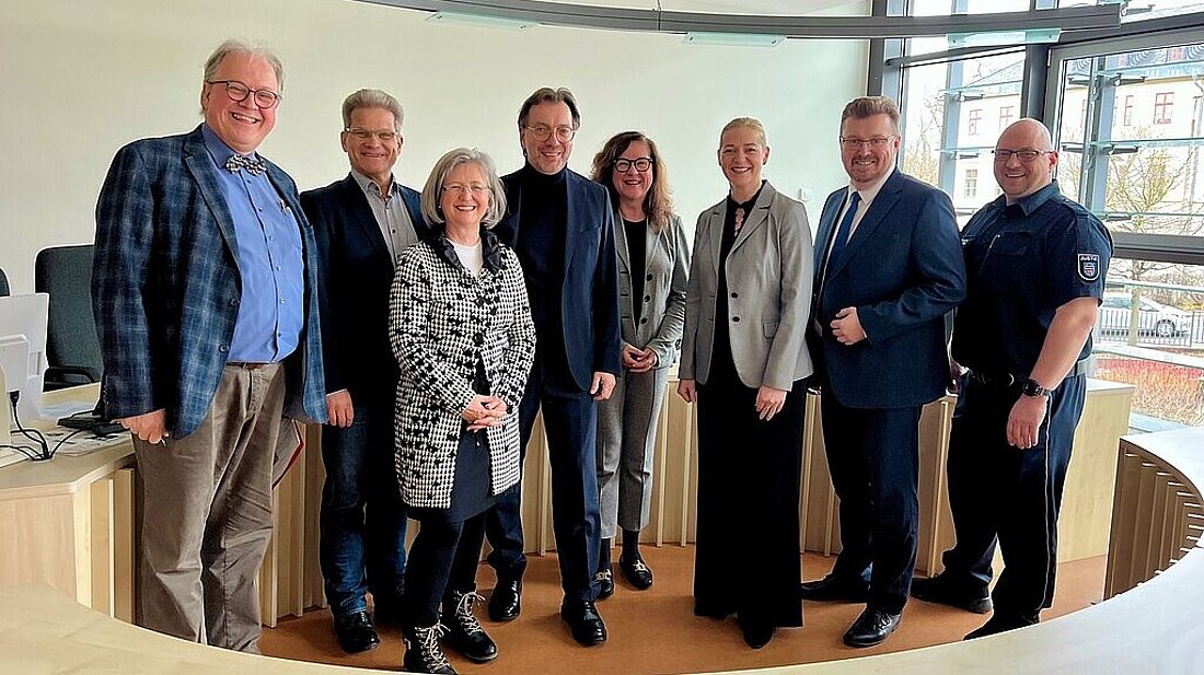 Justizministerin Beate Meißner sowie Staatssekretär Christian Klein und Bedienstete des Thüringer Oberverwaltungsgerichts stehen in einem Sitzungssaal.