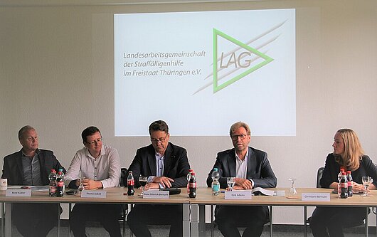 Minister Dirk Adams im Podium bei der Veranstaltung der Landesarbeitsgemeinschaft Straffälligenhilfe.