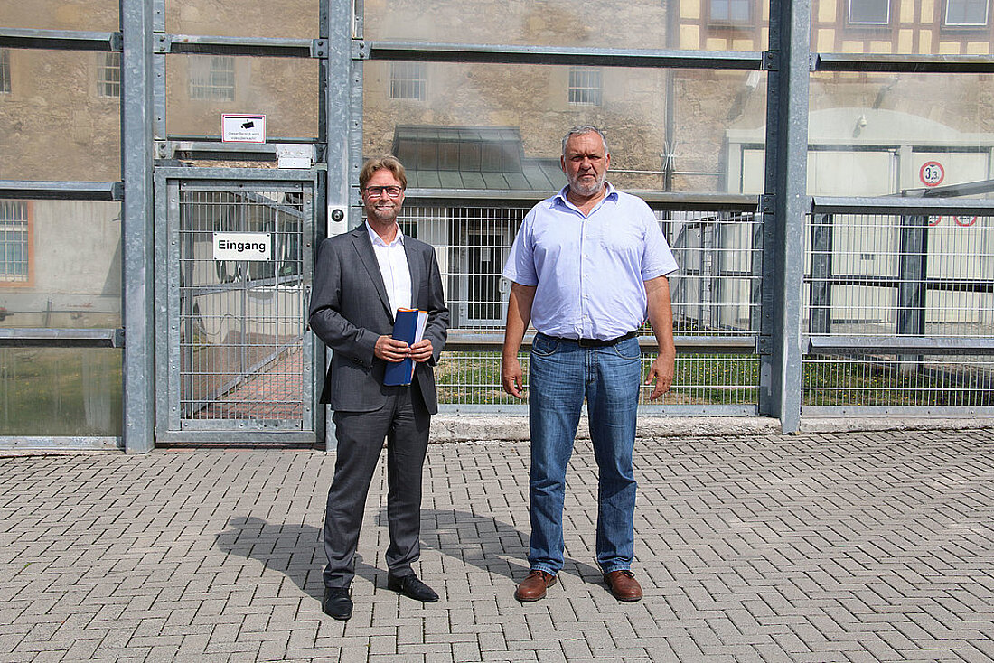 Justizminister Dirk Adams und der Anstaltsleiter Michael Kreisel vor der Justizvollzugsanstalt Untermaßfeld.