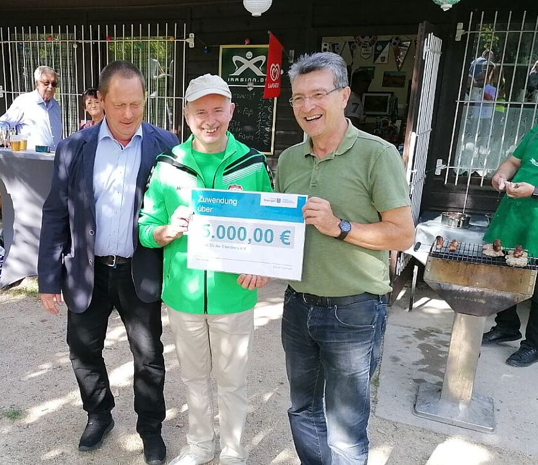 Minister Lauinger mit zwei weiteren Peronen des SV - Am Ettersberg - mit einem Lottomittelscheck über 5.000 Euro in den Händen haltend