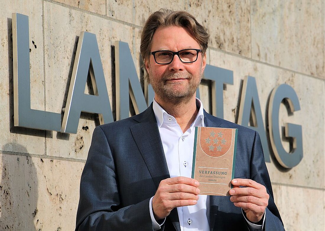 Minister Adams mit Verfassung vor Landtag