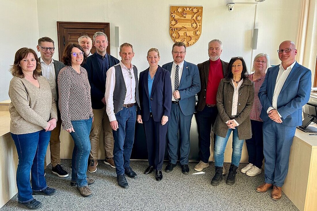 Justizministerin Beate Meißner und Staatssekretär Christian Klein mit Bediensteten des Finanzgerichts Gotha in einem Sitzungssaal des Gerichts.