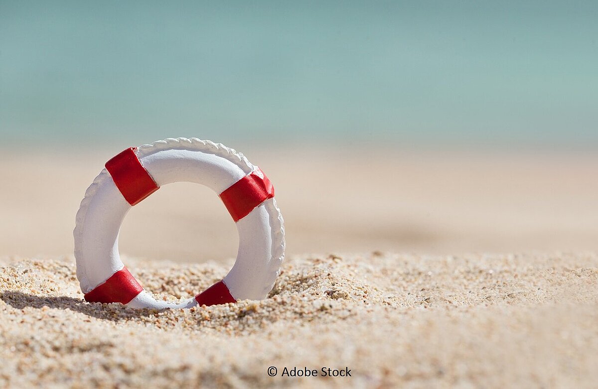 Ein Rettungsring steckt im Sand
