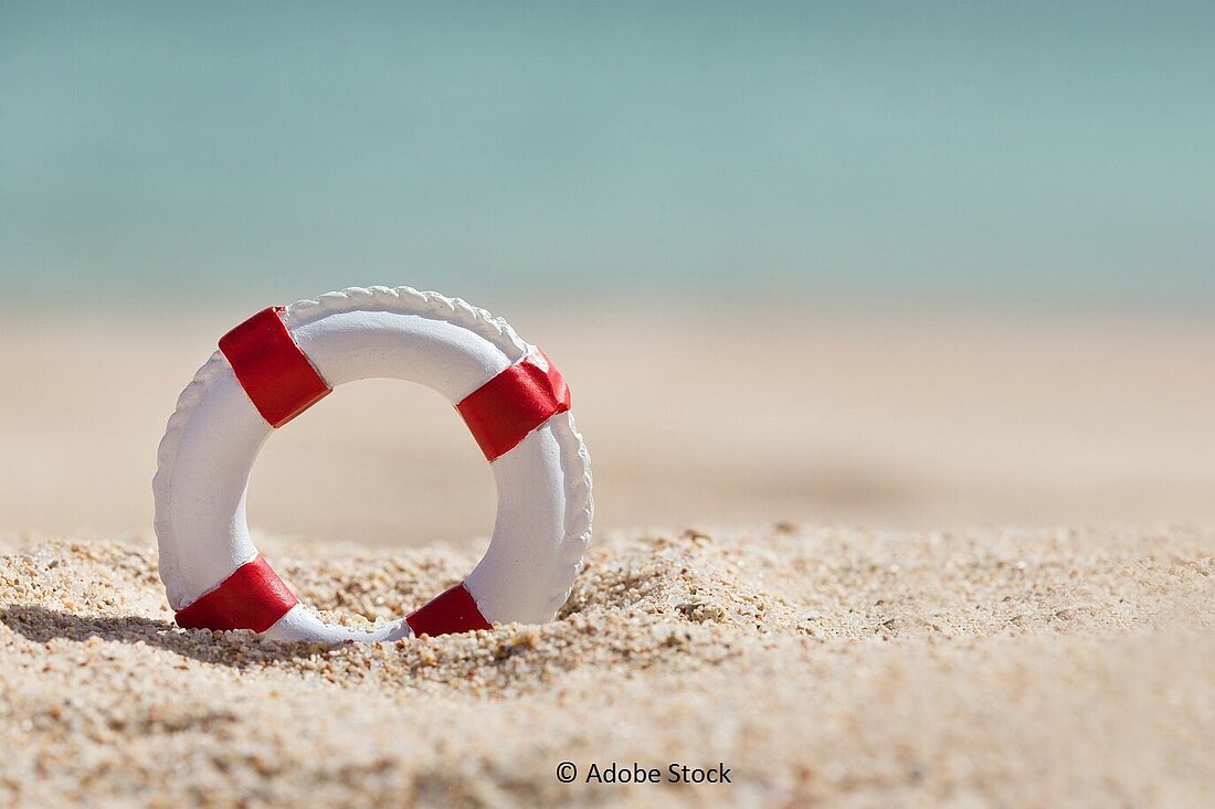 Ein Rettungsring steckt im Sand