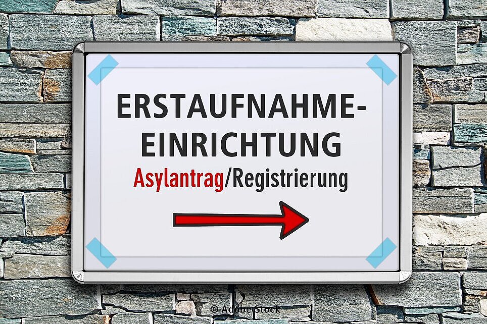 Ein Schild mit der Aufschrift Registrierung und Erstaufnahme von einer Steinwand (Foto: Adobe Stock)
