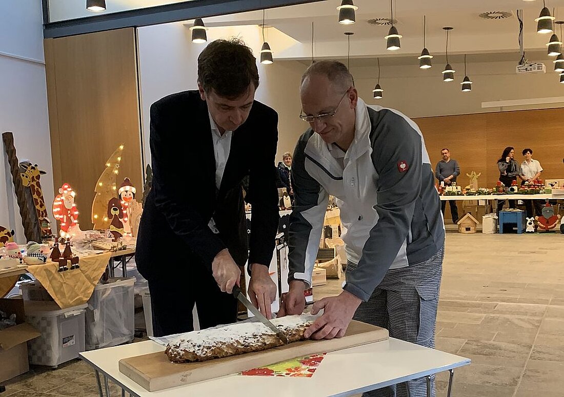 Staatssekretär Sebastian von Ammon und Bäckermeister Lars Raff von der JVA Tonna haben in der Rotunde im Erfurter Regierungsviertel mit dem traditionellen Stollenanschnitt den 14. Weihnachtsbasar des Thüringer Justizvollzuges eröffnet.