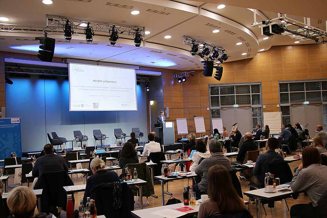 Staatssekretär Sebastian von Ammon hält ein Grußwort bei der Fachtagung "Zwischen Delinquenz und Schutzbedürfnigkeit - Ansätze und Herausforderungen zum Umgang mit geflüchteten Männern in Gemeinschaftsunterkünften".