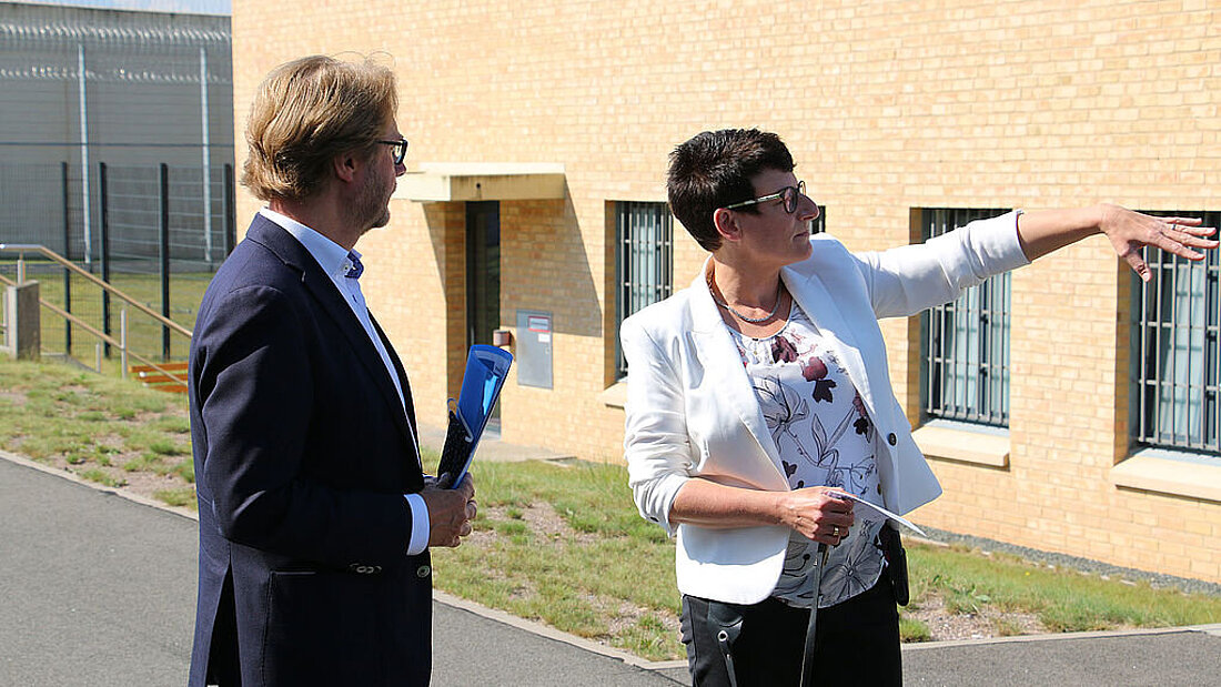 Justizminister Dirk Adams und die Leiterin machen einen Rundgangs über das Gelände der Jugendstrafanstalt Arnstadt