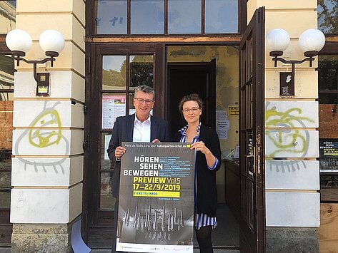 Minister Lauinger hält mit einer weiteren Person ein Werbeschild für eine Veranstaltung im Kulturquartier Erfurt e.V.