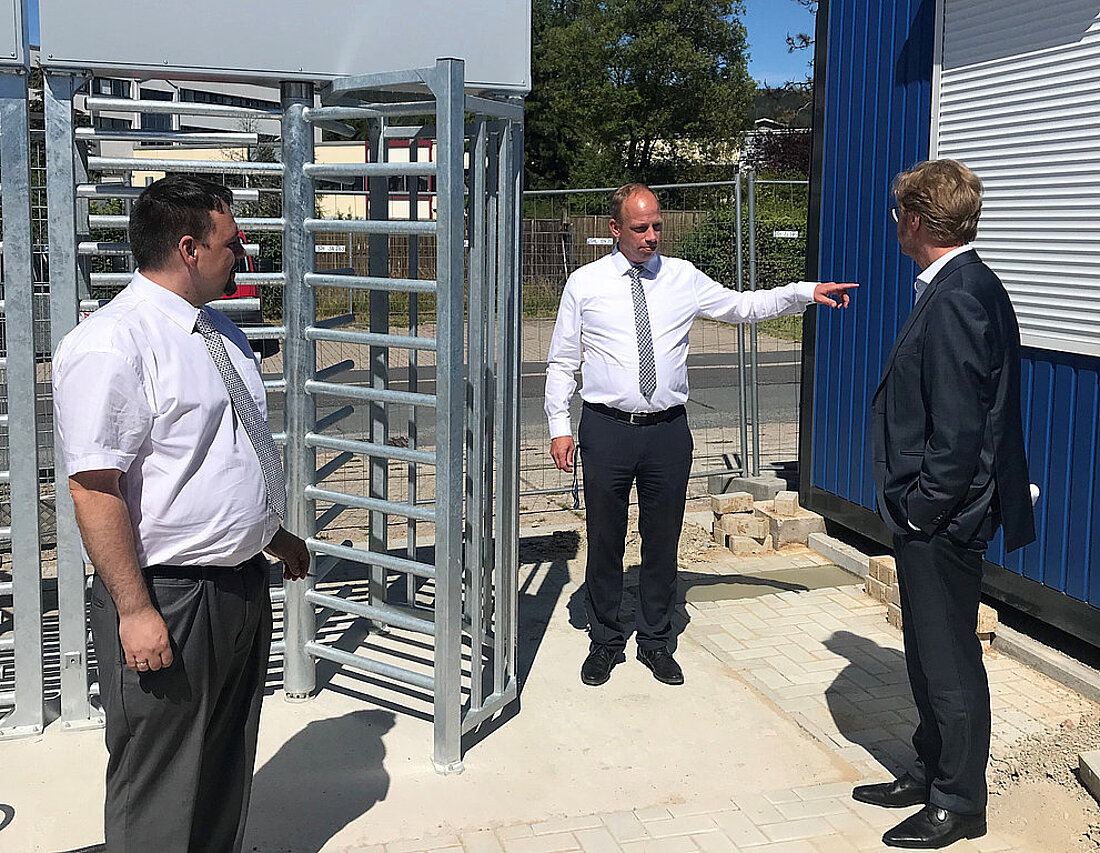 Migrationsminister Dirk Adams im Gespräch mit der Hausleitung der Erstaufnahmeeinrichtung beim Drehkreuz im Eingangsbereich.