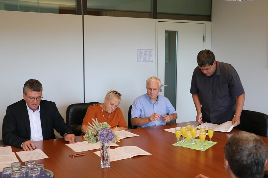 Minister mit 3 weiteren Personen während der Unterzeichnung