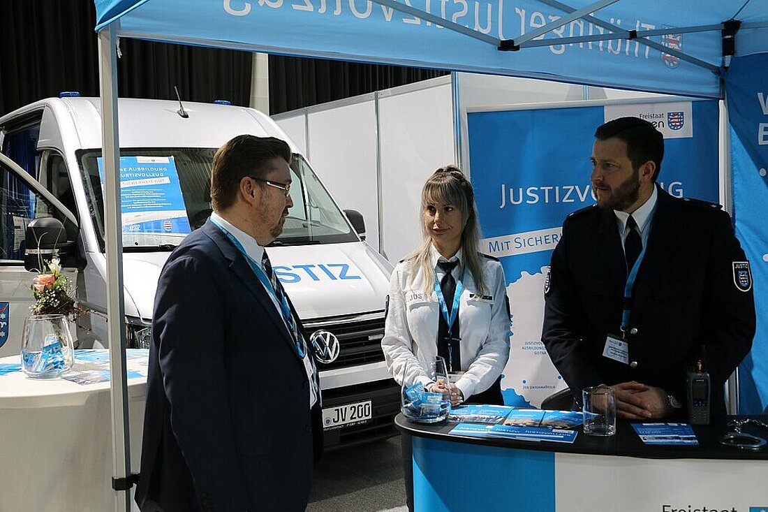 Justizstaatssekretär Christian Klein im Gespräch mit zwei Bediensteten des Thüringer Justizvollzuges auf der Thüringen-Ausstellung