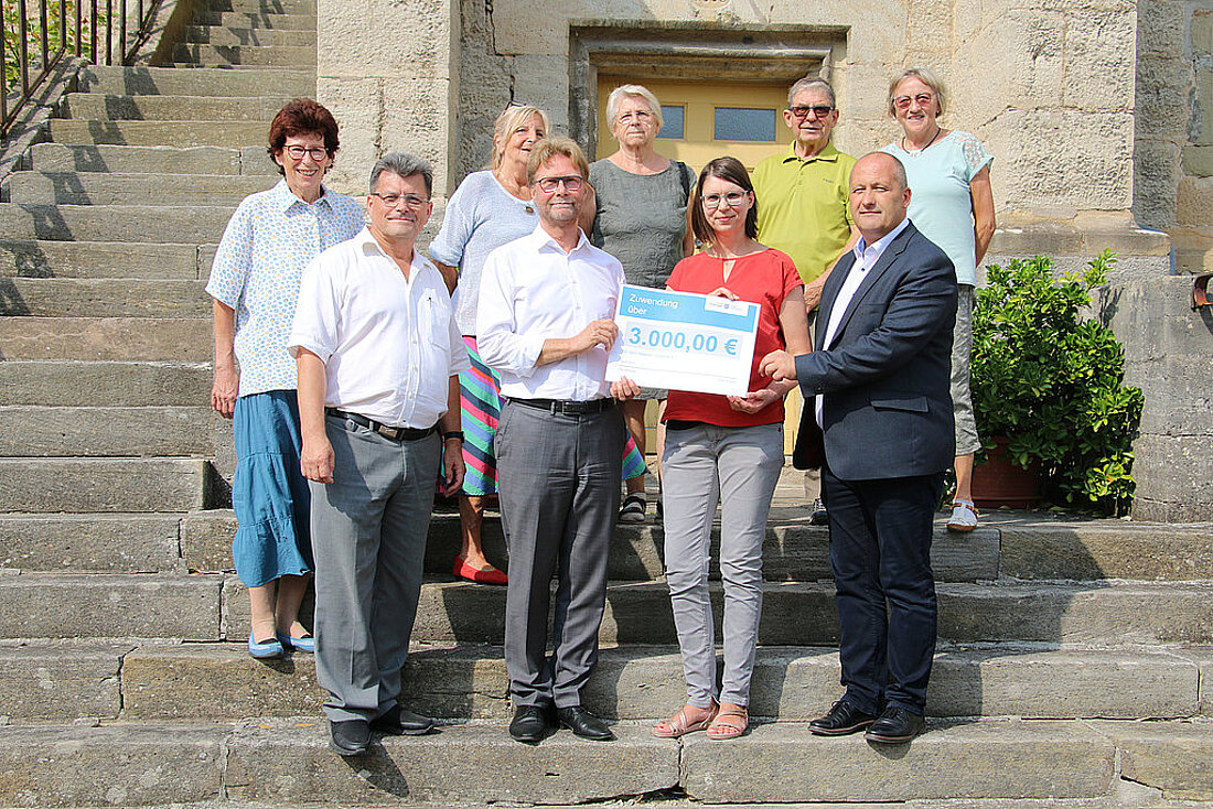 Minister Dirk Adams und Mitglieder der Heener Vereine e.V. bei der Lottomittelübergabe vor der Johanniskirche.