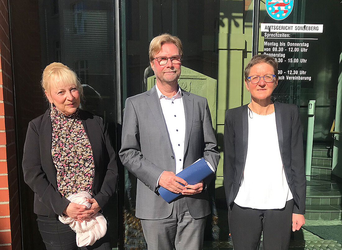 Justizminister Dirk Adams steht zusammen mit der Landgerichtspräsidentin Sonja Friebertshäuser und der Amtsgerichtsdirektorin Grit Stolze vor dem Amtsgericht Sonneberg.