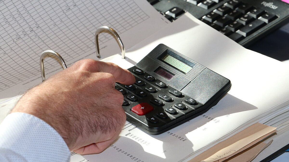 eine Taschenrechner bedienende Hand