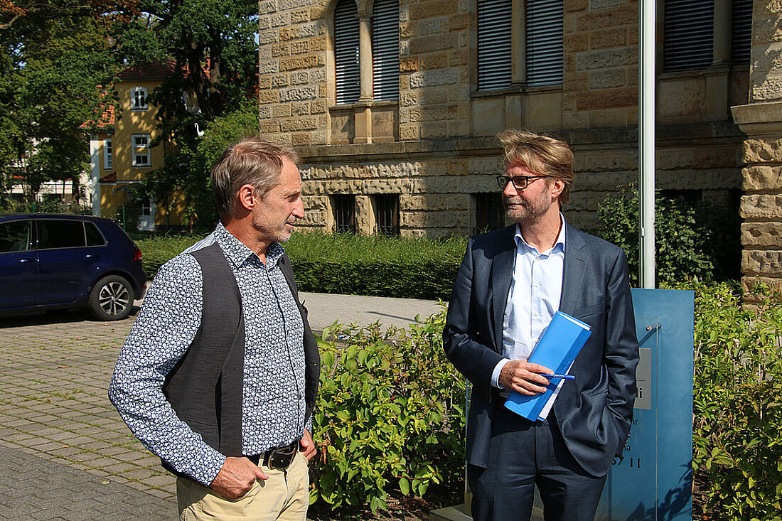 Der Präsident Gunnar Skerhut und Justizminister Dirk Adams stehen vor dem Thüringer Finanzgericht und unterhalten sich. Finanzgerichts in Gotha