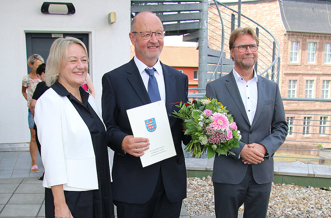 Ruhestand Direktor Bärthel Sabine Dräger, Direktor Jürgen Bärthel mit Blumenstrauß und Justizminister Dirk Adams vor dem Amtsgericht Heiligenstadt.