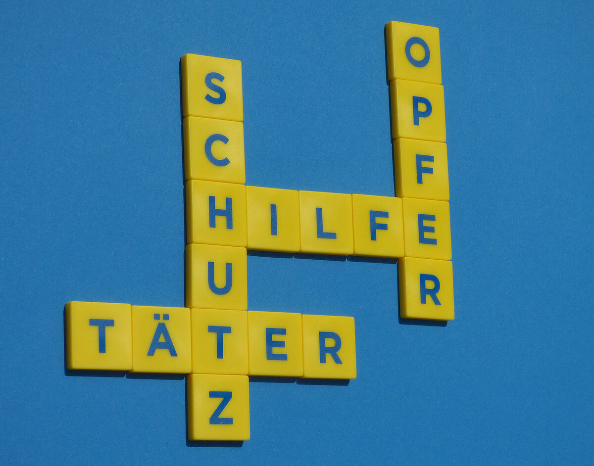 Schriftzüge Opfer Hilfe Schutz und Täter aus Buchstabenbausteinen gelegt