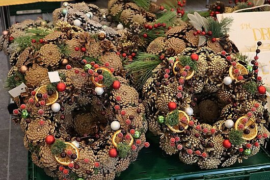 Ein weihnachtlich dekorierter Kranz mit Zapfen und Beeren