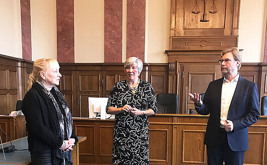 Justizminister Dirk Adams im Gespräch mit der Landgerichtspräsidentin Sonja Friebertshäuser und der Amtsgerichtsdirektorin Regina Jung im Sitzungssaal des Amtsgerichts Eisenach.