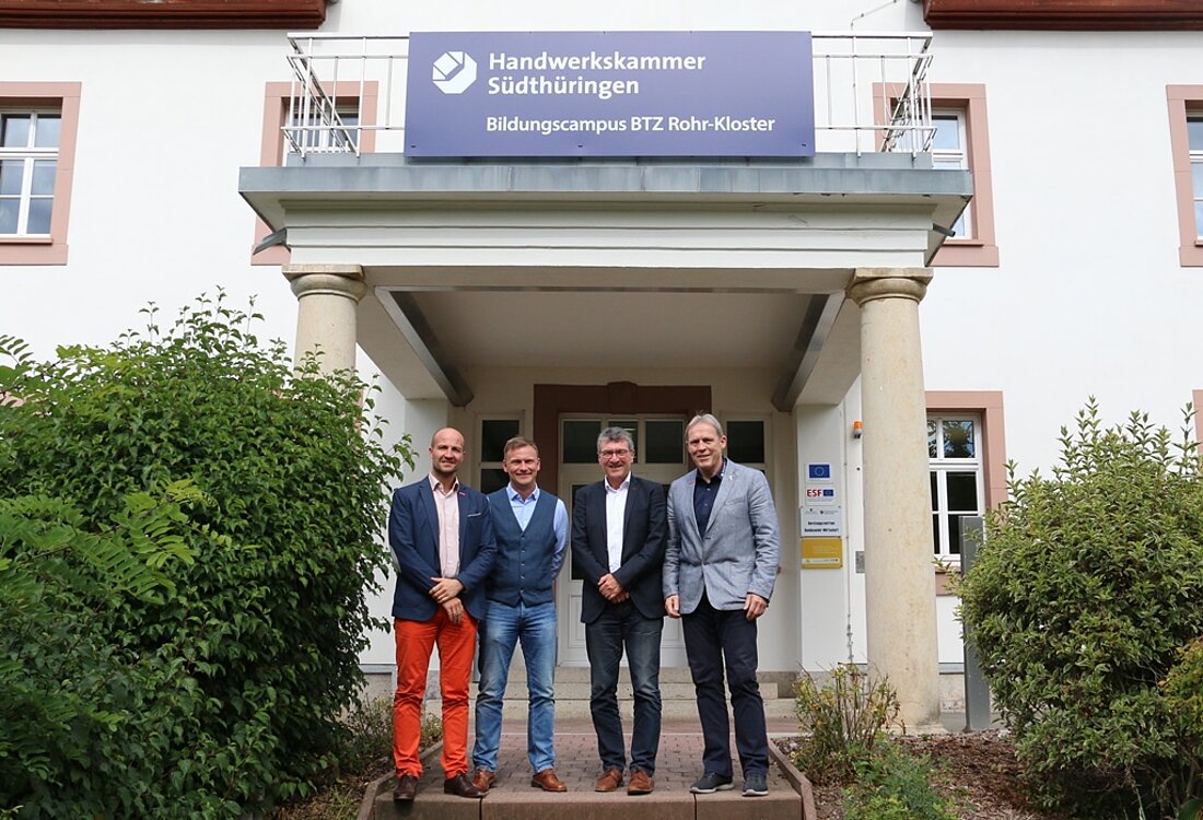 Minister Lauinger mit Präsidenten der HWK Südthüringen, Manfred Scharfenberger, dem Bereichsleiter des BTZ, Alexander Ladwig, und dem Projektleiter, Oliver Kramer, stehend vor dem Gebäude des Bildungszentrums in freudiger Runde